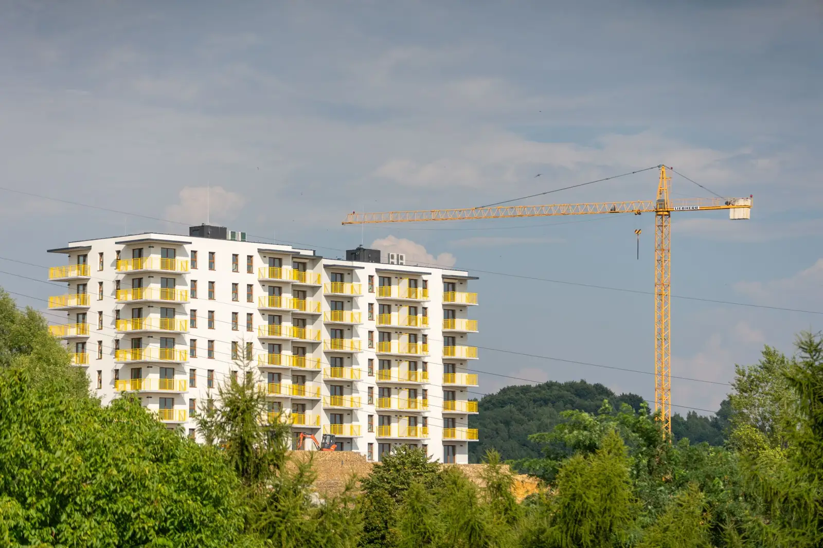 A tower crane beside a new mid-rise apartment building