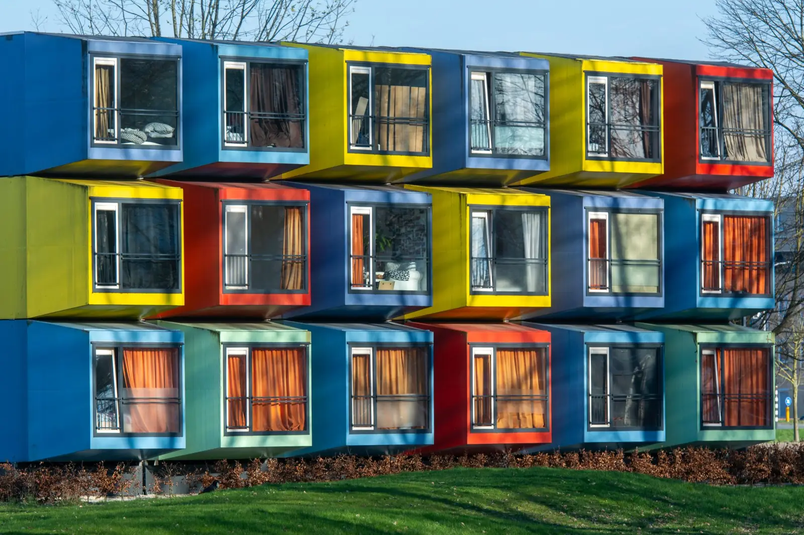 Stacked box-shaped housing units in red, yellow, green and blue