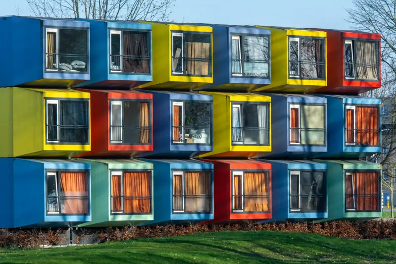 Stacked box-shaped housing units in red, yellow, green and blue